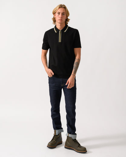 a full length studio photograph of a model wearing a PS Paul Smith Mens Zip Polo Shirt with Tipped Collar and Placket in 79 Black