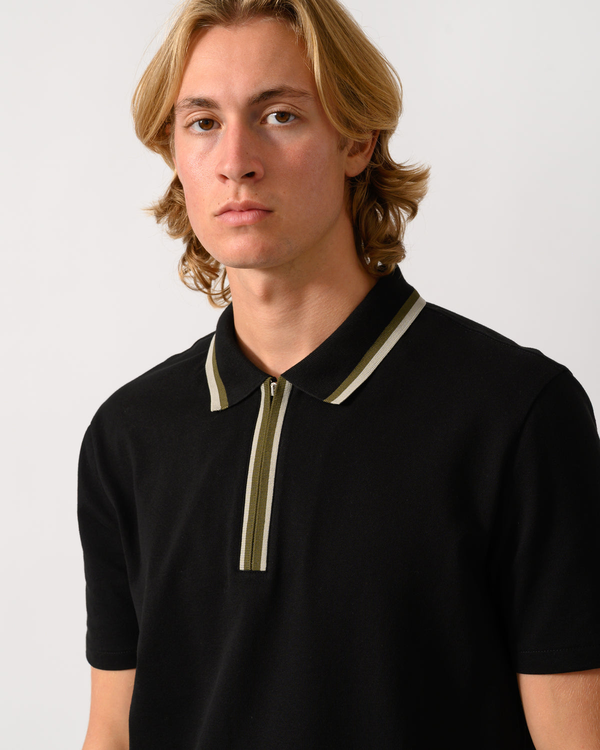 close up studio photograph of a model wearing a PS Paul Smith Mens Zip Polo Shirt with Tipped Collar and Placket in 79 Black