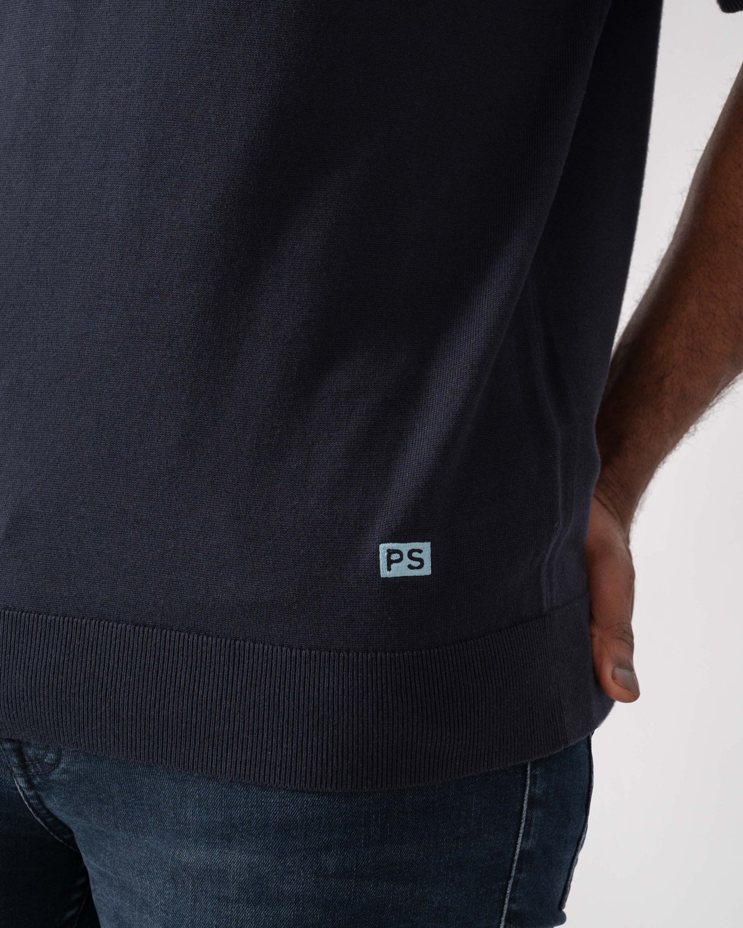 Model wearing PS Paul Smith Mens Short Sleeve Knit Polo in 49 Blue - Patch detail