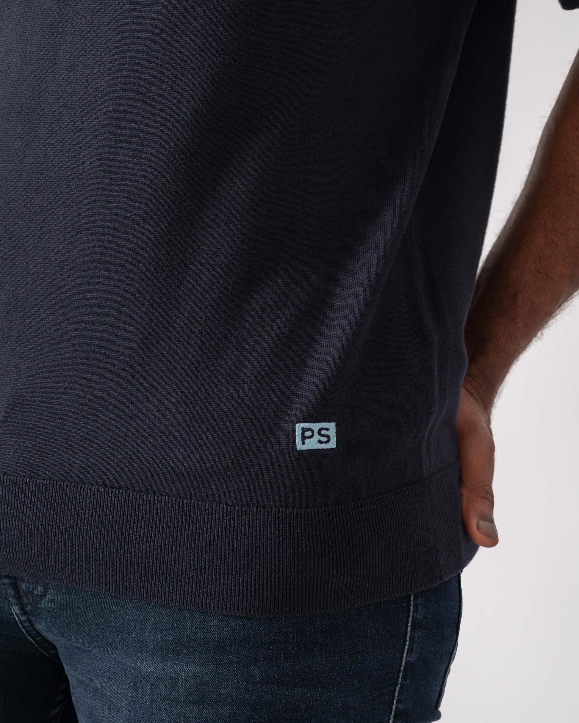Model wearing PS Paul Smith Mens Short Sleeve Knit Polo in 49 Blue - Patch detail