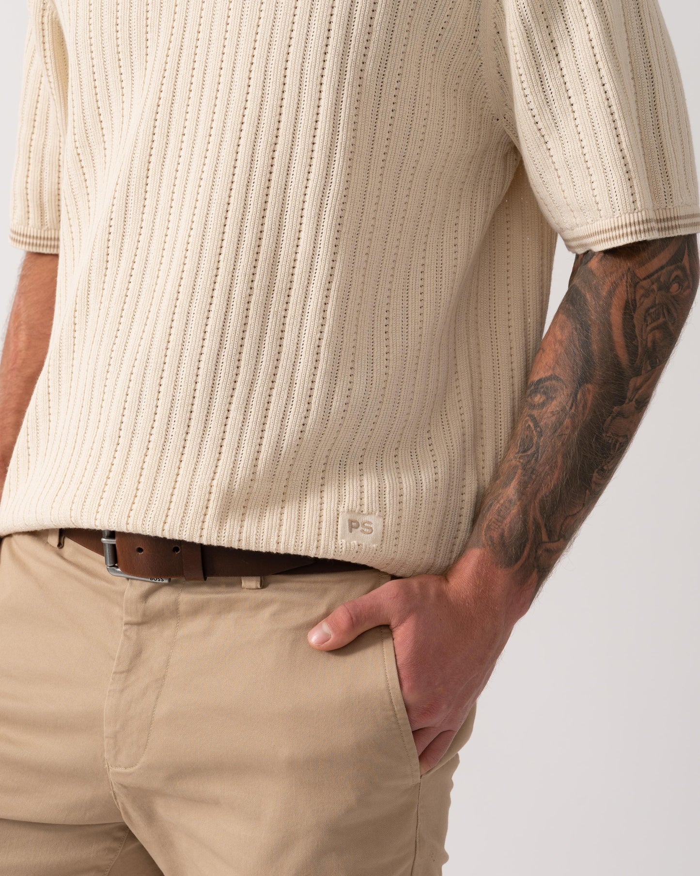 Model wearing PS Paul Smith Mens Rib Knitted Polo in 04 White - Logo detail