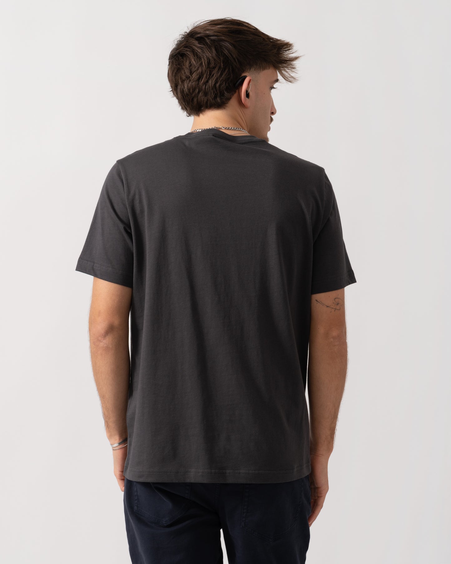 Person wearing a black t-shirt on a plain background