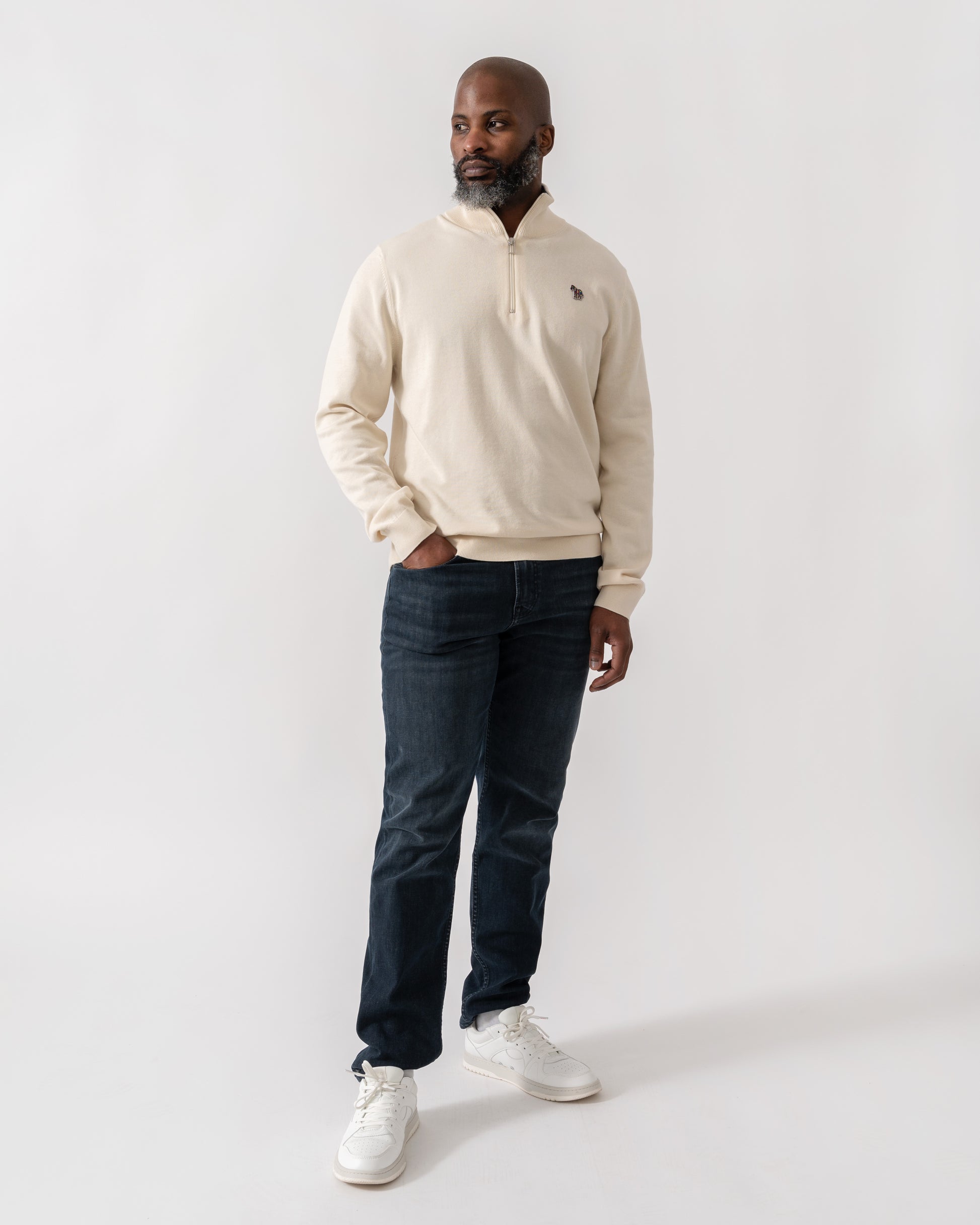 Model wearing PS Paul Smith Mens Zip Neck Zebra Badge Sweater in 04 White -full length