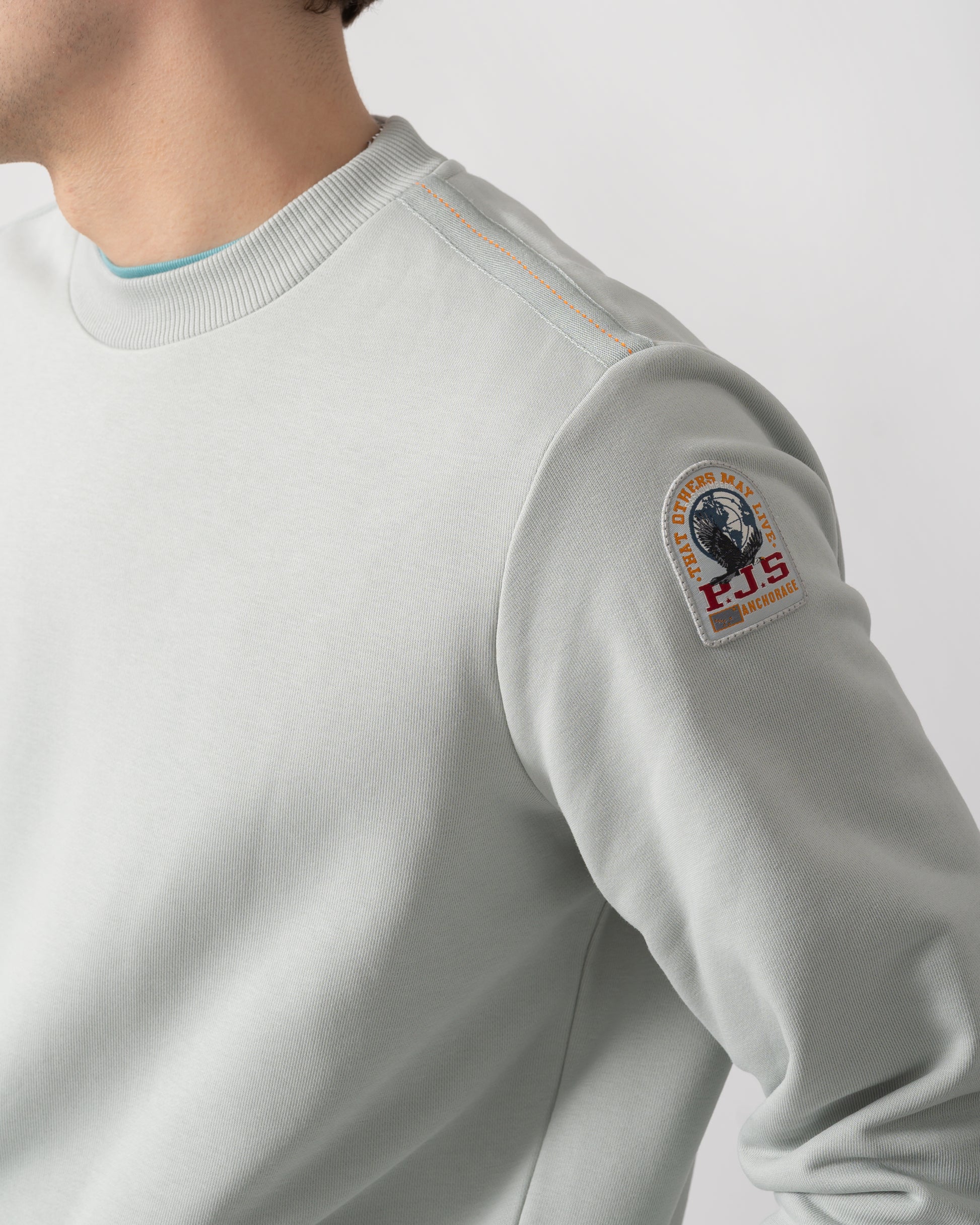 logo shot of a model wearing a Parajumpers K2 Crew Neck Mens Sweatshirt in Fresh Grey 271