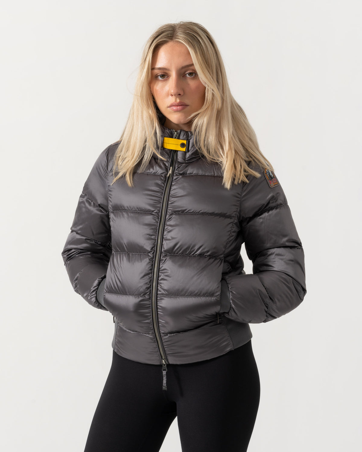 Model with hands in pocket on the Parajumpers Mariah Womens Hooded Down Bomber Jacket - Graphite Orchid 124