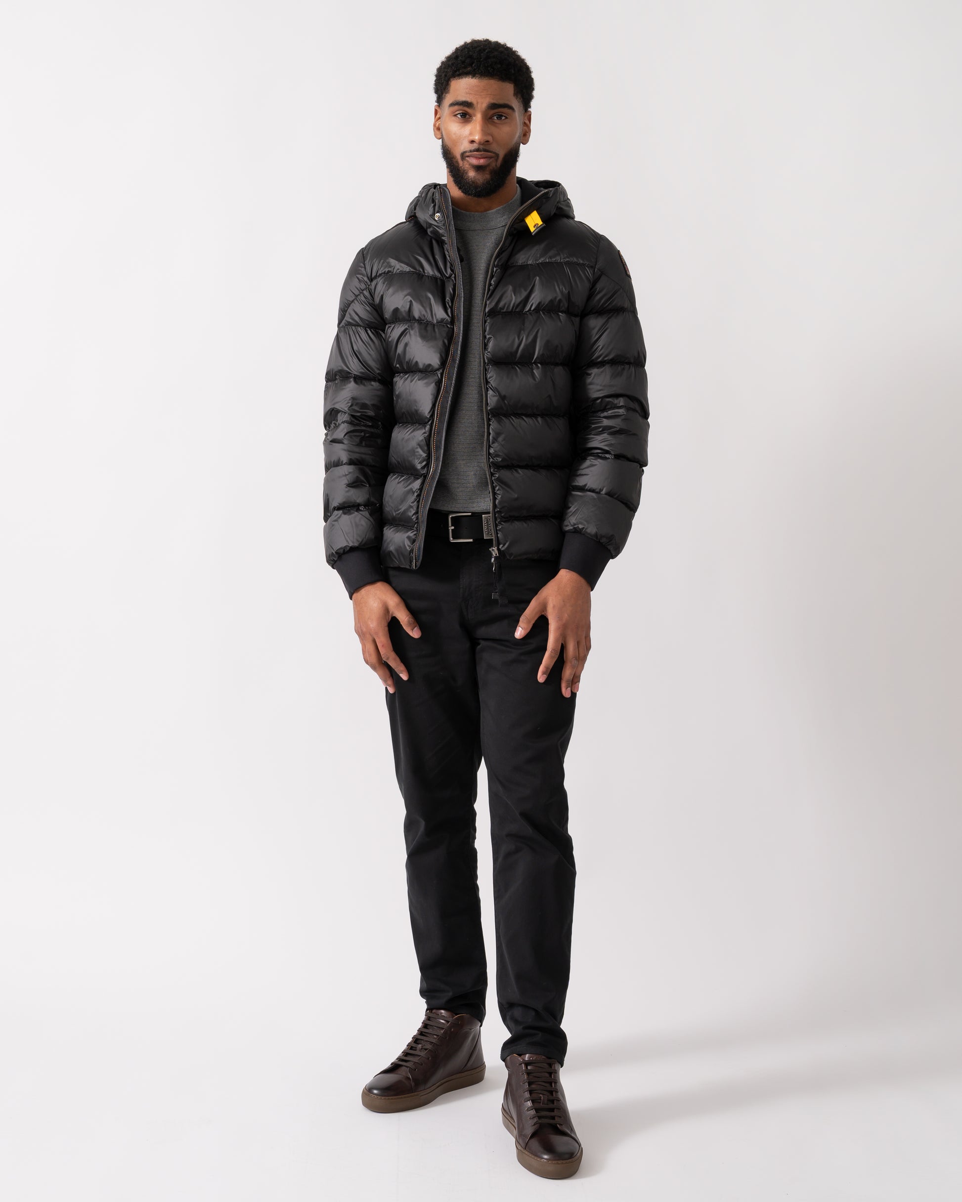 wide shot of a model wearing a Parajumpers Pharrell Mens Hooded Down Bomber in Black