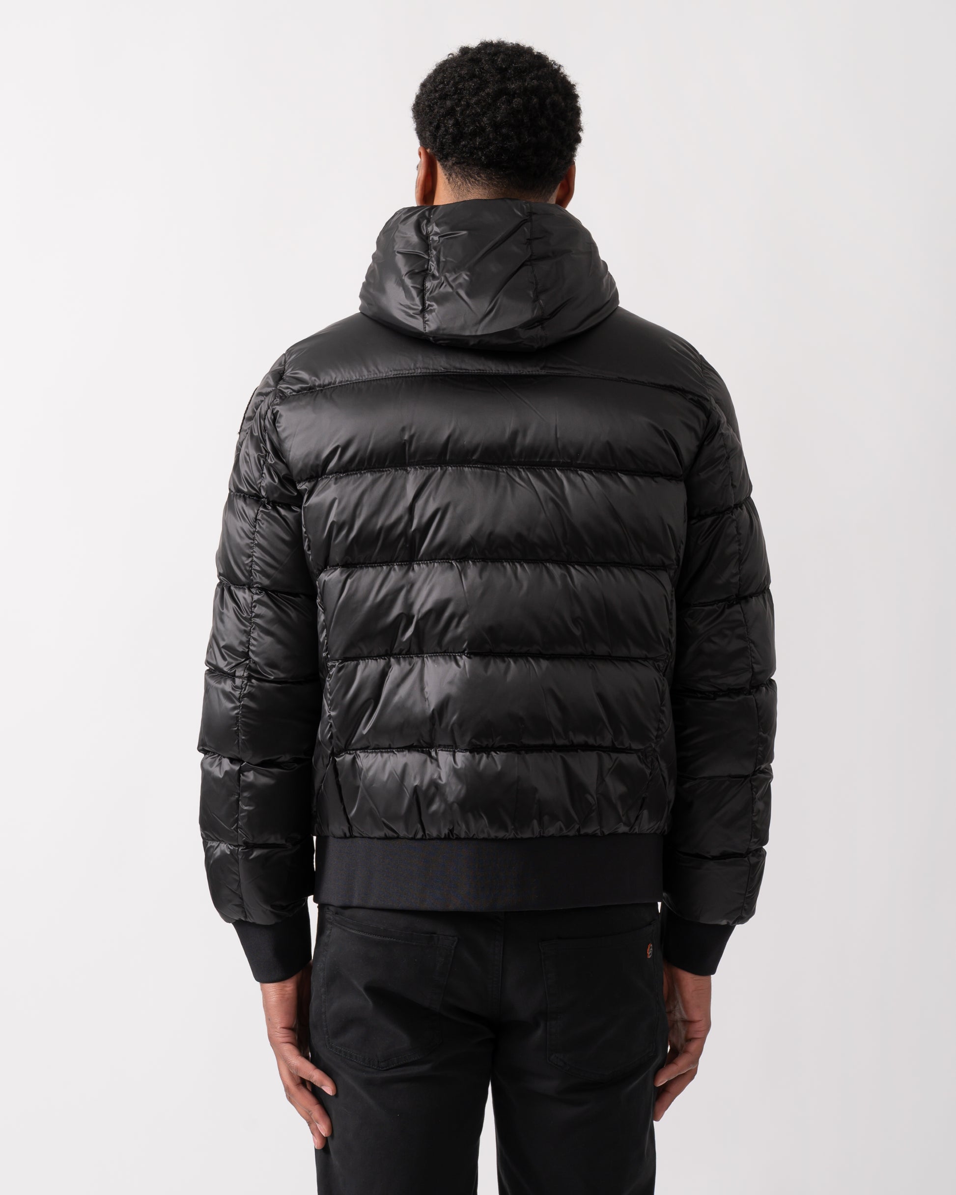 back shot of a model wearing a Parajumpers Pharrell Mens Hooded Down Bomber in Black