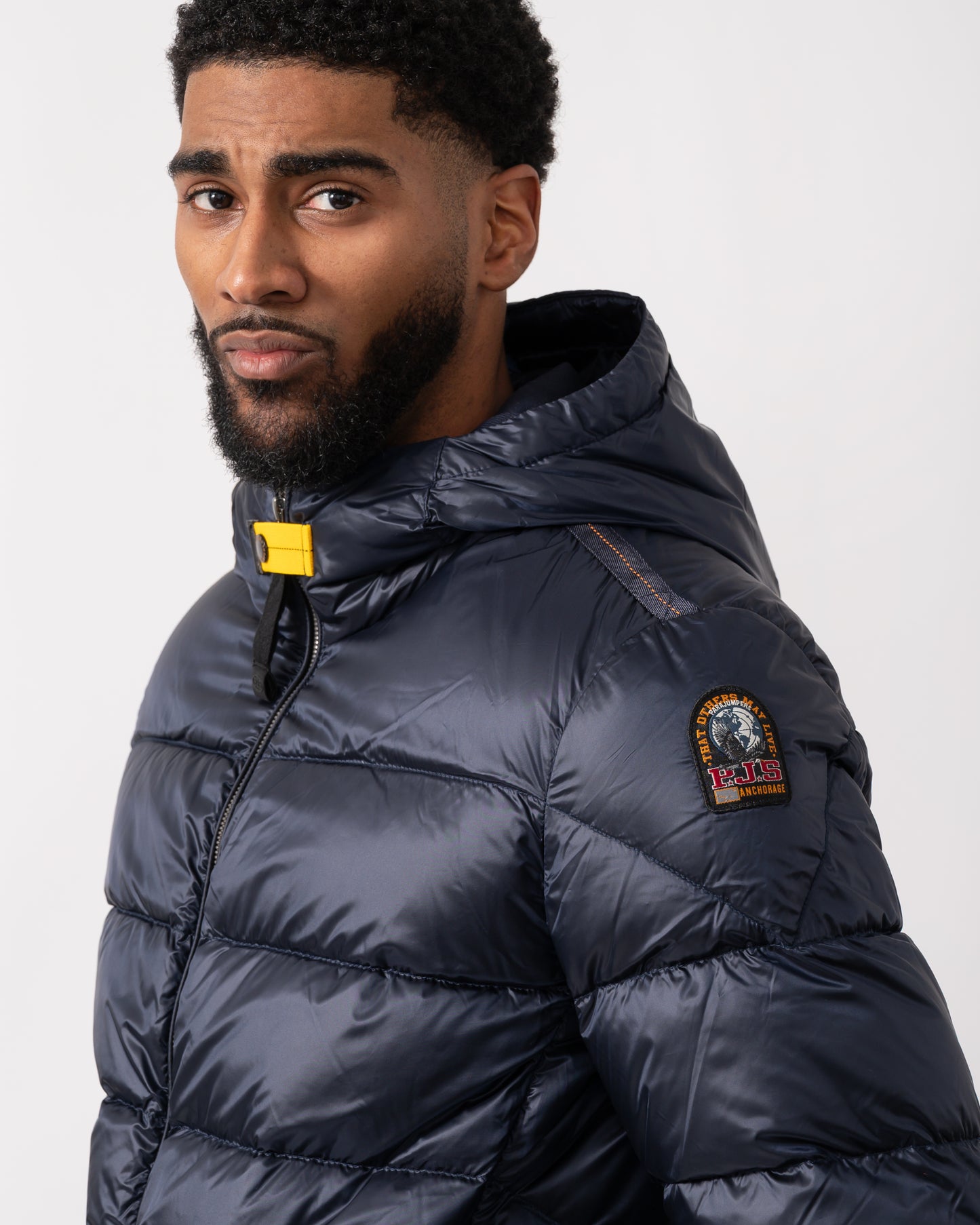 close up of a model wearing a Parajumpers Pharrell Mens Hooded Down Bomber in Blue Navy