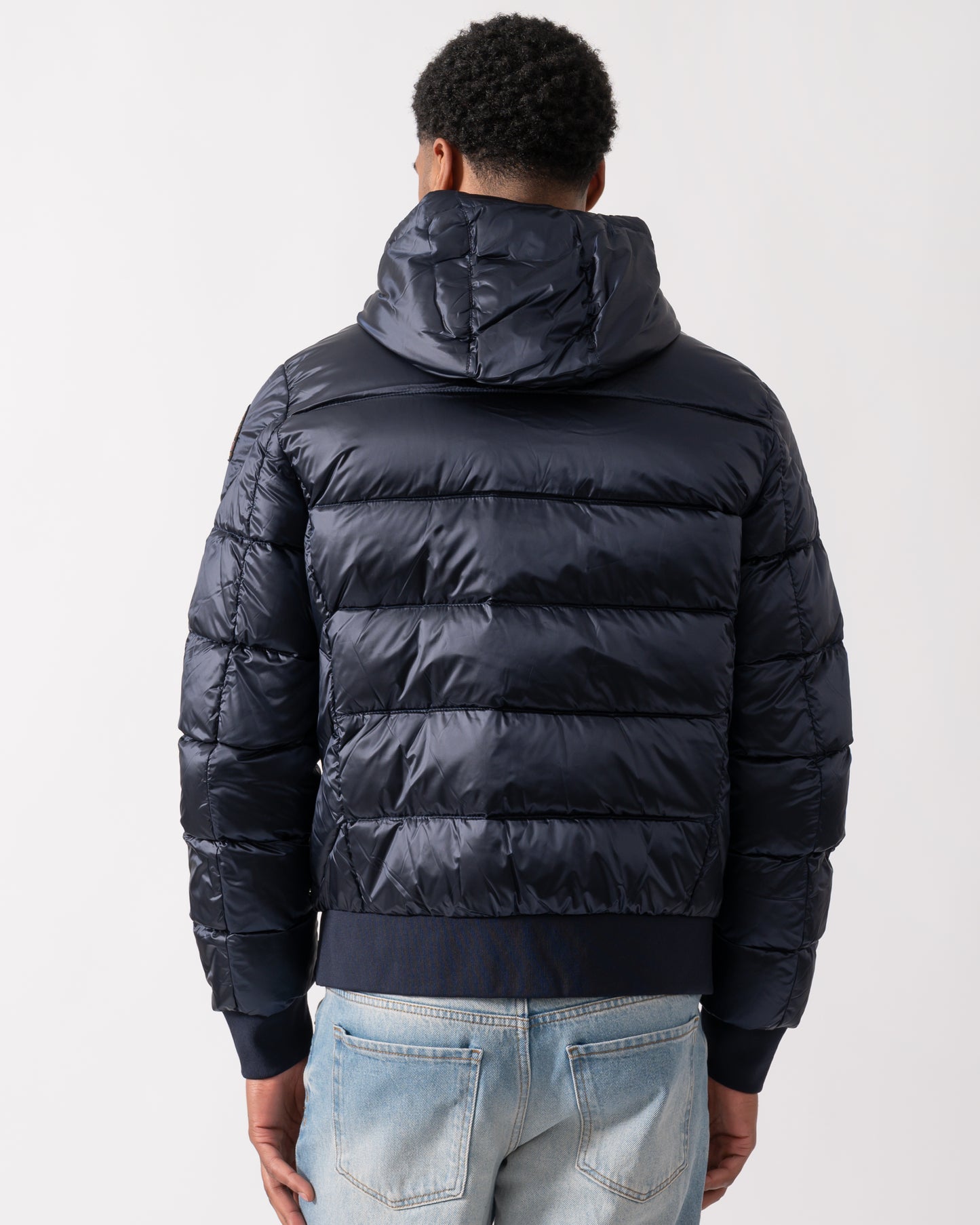 back of a model wearing a Parajumpers Pharrell Mens Hooded Down Bomber in Blue Navy