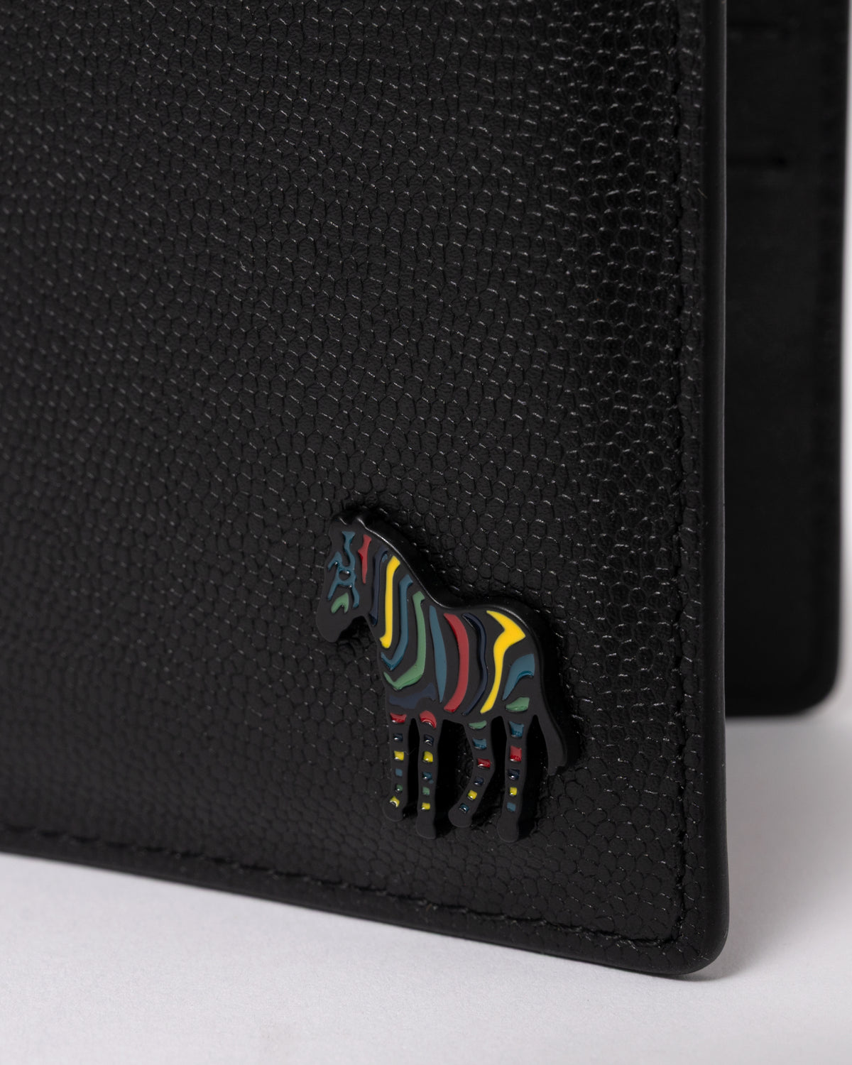 studio photograph showing logo detail of a Paul Smith Mens Zebra Badge Billfold Wallet in 79 Black