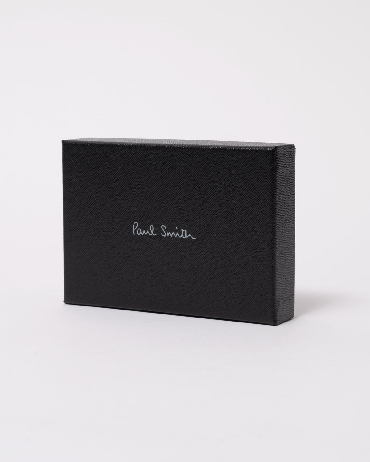 studio photograph showing the packaging of a Paul Smith Mens Zebra Badge Card Holder in 79 Black