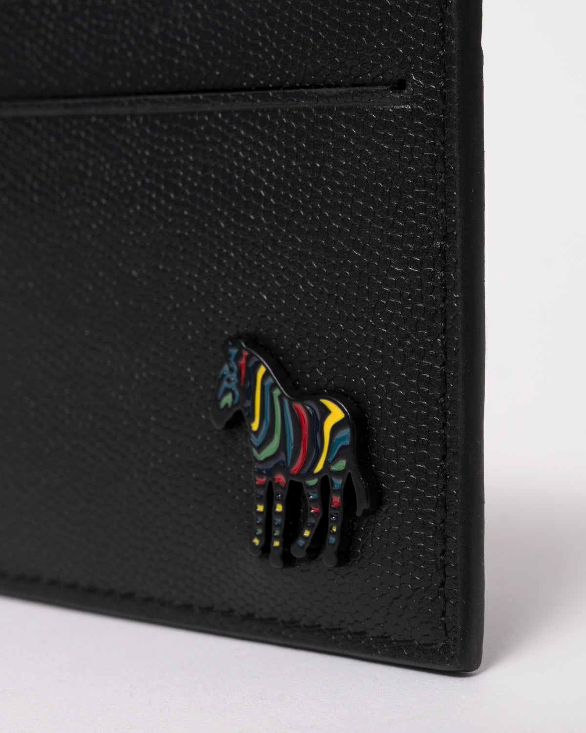 studio photograph showing the logo detail of a Paul Smith Mens Zebra Badge Card Holder in 79 Black