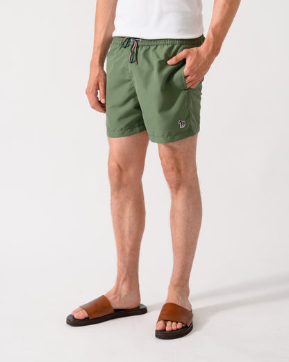 model wearing a pair of Paul Smith Mens Zebra Logo Swim Shorts in 35A Green