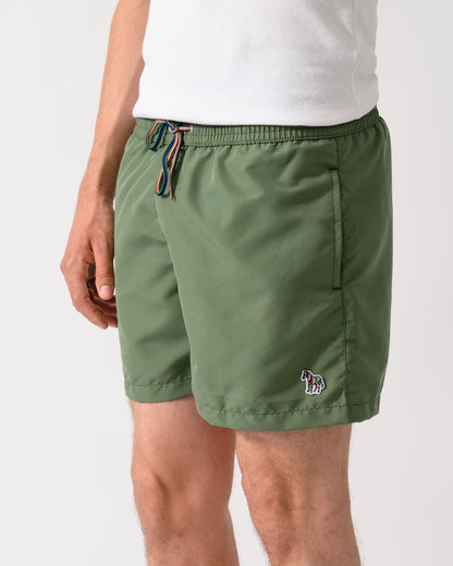 close up shot of a model wearing a pair of Paul Smith Mens Zebra Logo Swim Shorts in 35A Green