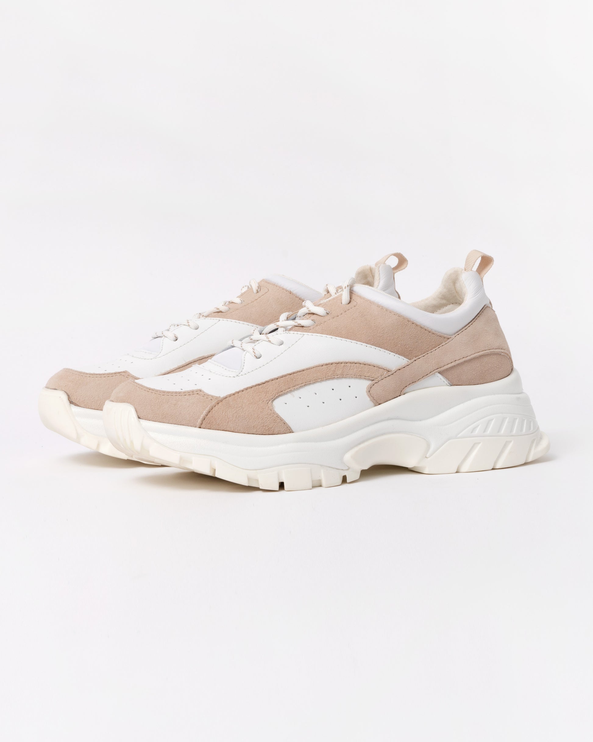 Beige and white sneakers on a light gray background