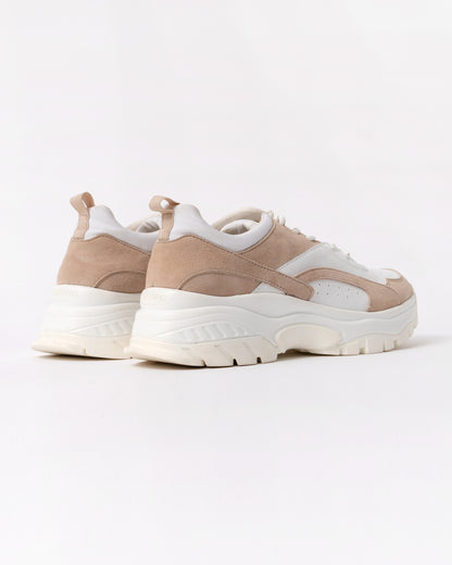 Pair of beige and white sneakers on a light gray background