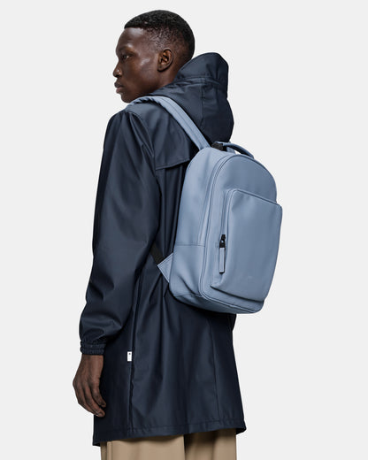 model carrying a Rains Book Daypack in 172 Blue Dusk
