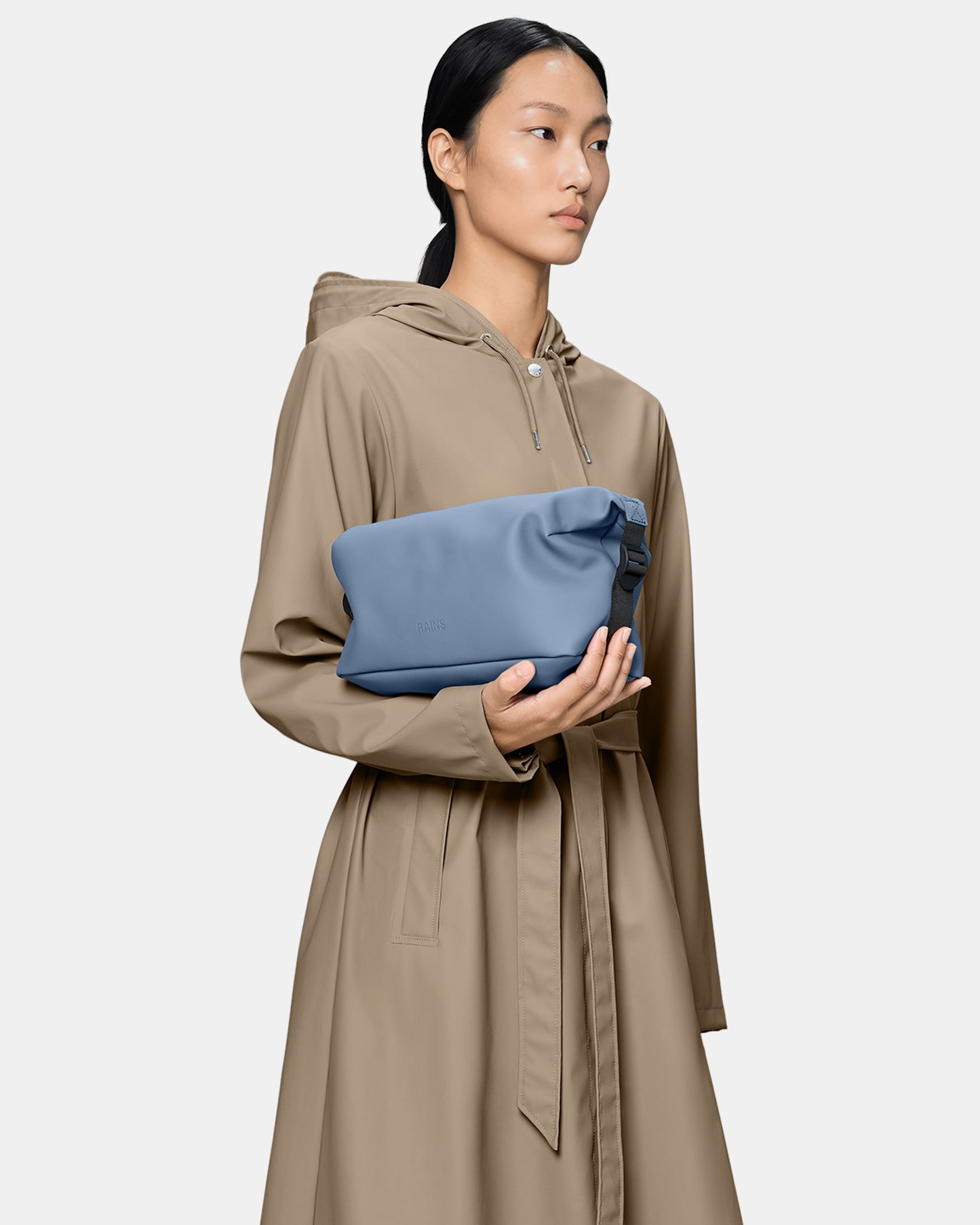 model holding a Rains Hilo Wash Bag in 172 Blue Dusk