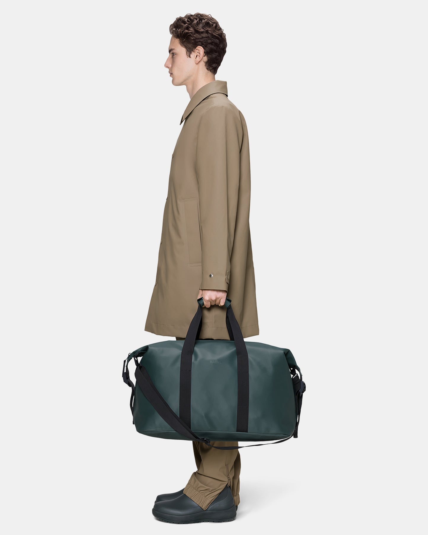 model holding a Rains Hilo Weekend Bag in 175 Mystique