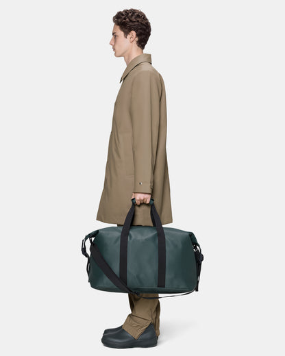 model holding a Rains Hilo Weekend Bag in 175 Mystique