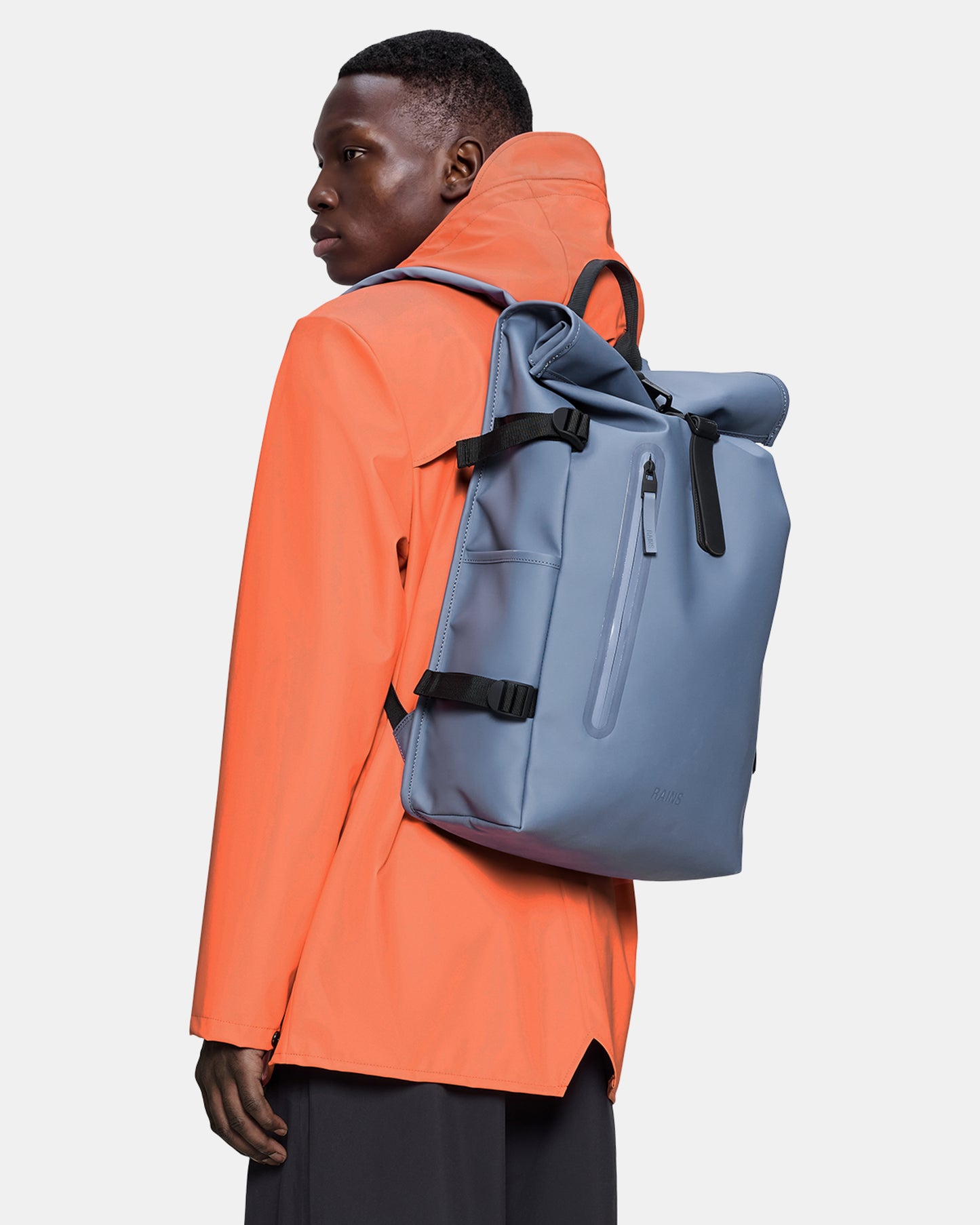 model carrying a Rains Rolltop Rucksack Large in 172 Blue Dusk
