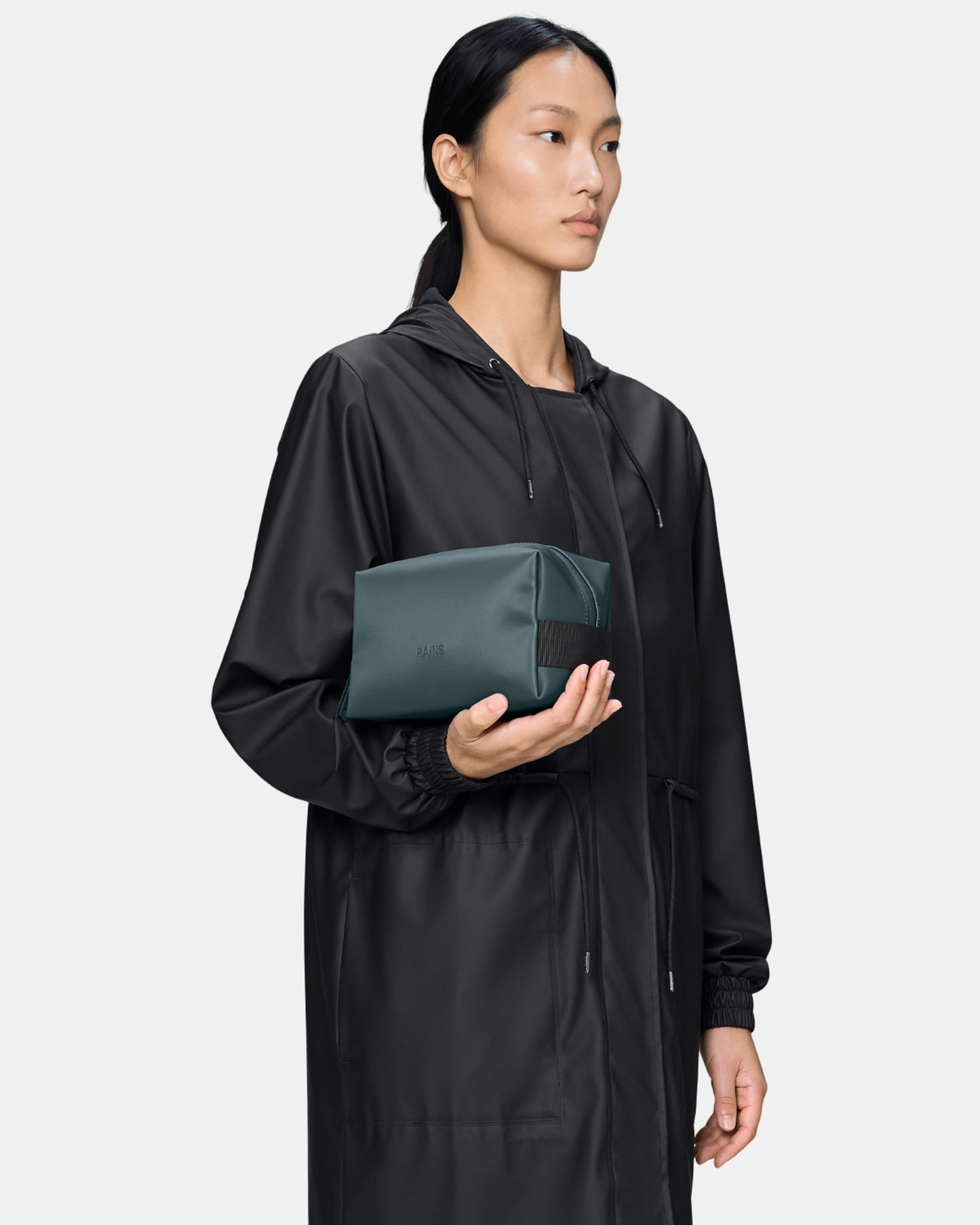 model holding a Rains Wash Bag Small in 175 Mystique