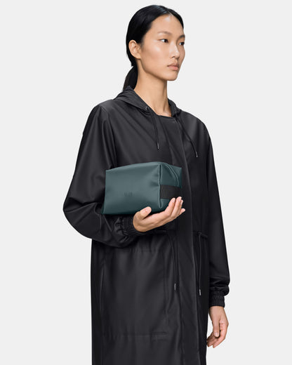 model holding a Rains Wash Bag Small in 175 Mystique