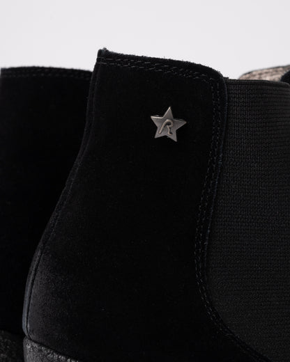 Black sneaker with a star-shaped logo on a light gray background