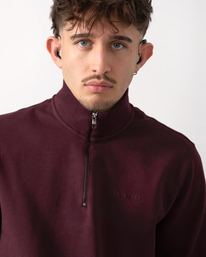 close up shot of a Model wearing a Ted Baker Actos Mens 1/4 Zip Sweatshirt in Maroon