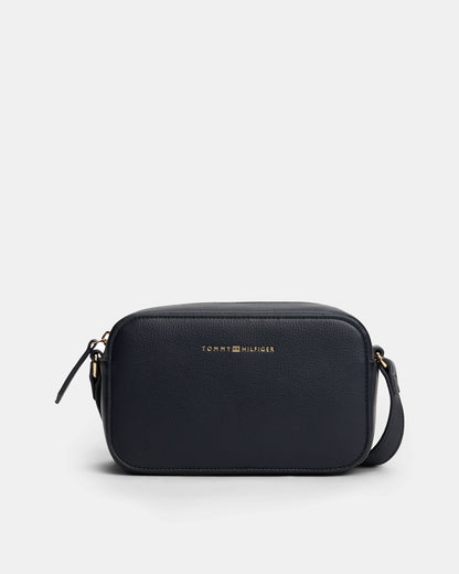 Black crossbody bag with Tommy Hilfiger logo on a light grey background