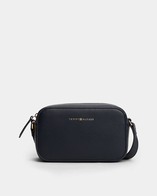 Black crossbody bag with Tommy Hilfiger logo on a light grey background