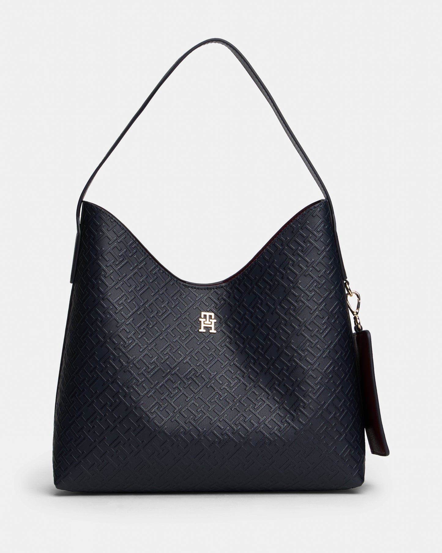 Black textured handbag with a visible Tommy Hilfiger logo on a light gray background