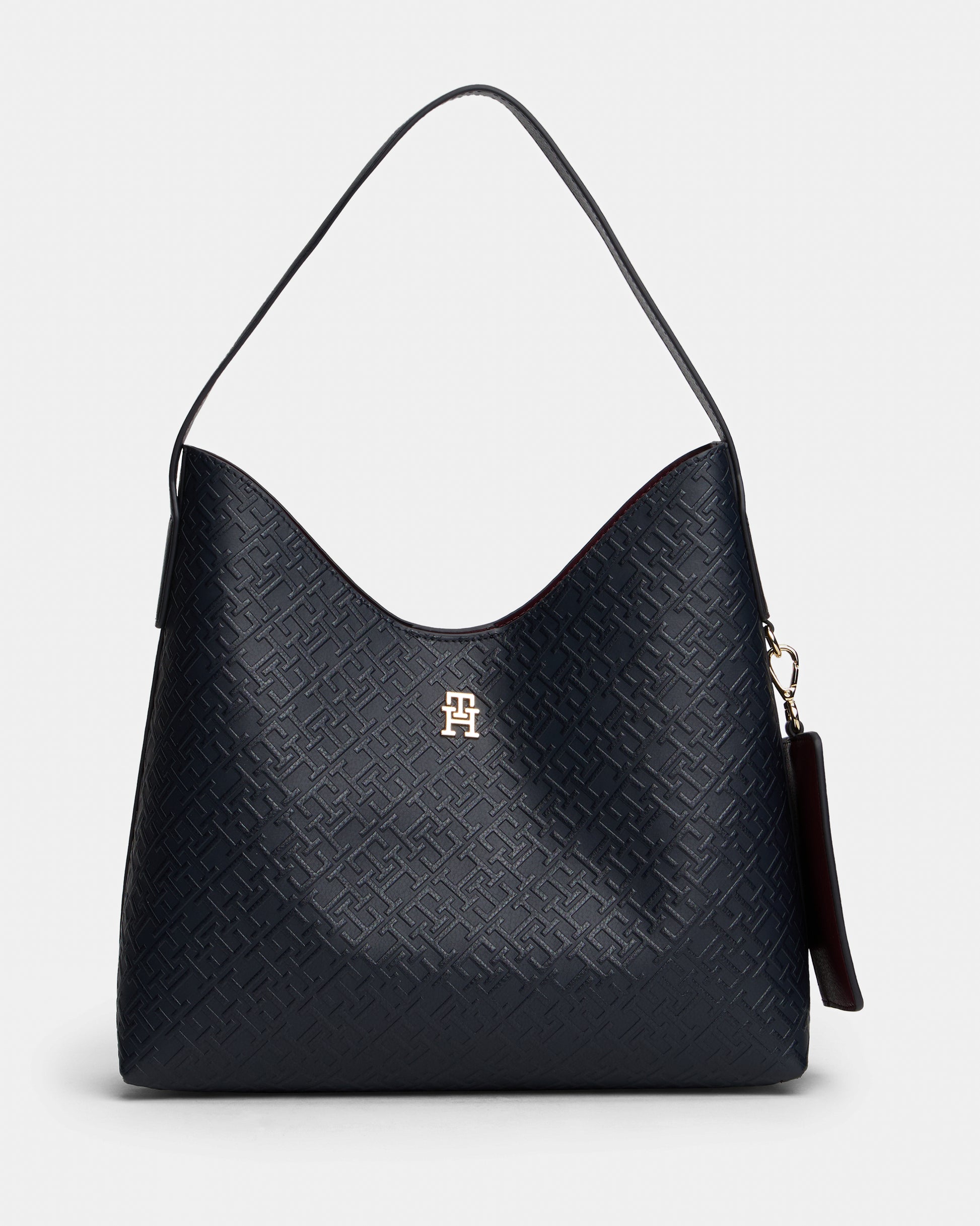 Black textured handbag with a visible Tommy Hilfiger logo on a light gray background