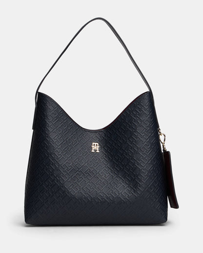 Black textured handbag with a visible Tommy Hilfiger logo on a light gray background