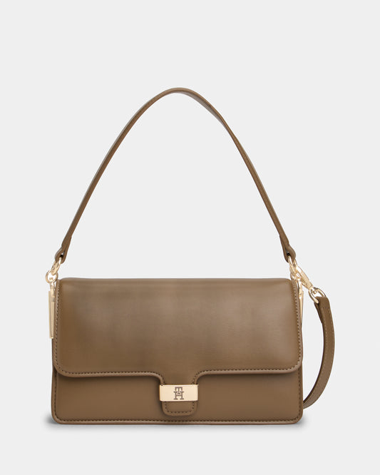 Brown Tommy Hilfiger handbag with a gold clasp on a light grey background