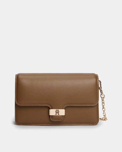 Brown Tommy Hilfiger handbag with a gold chain on a light grey background