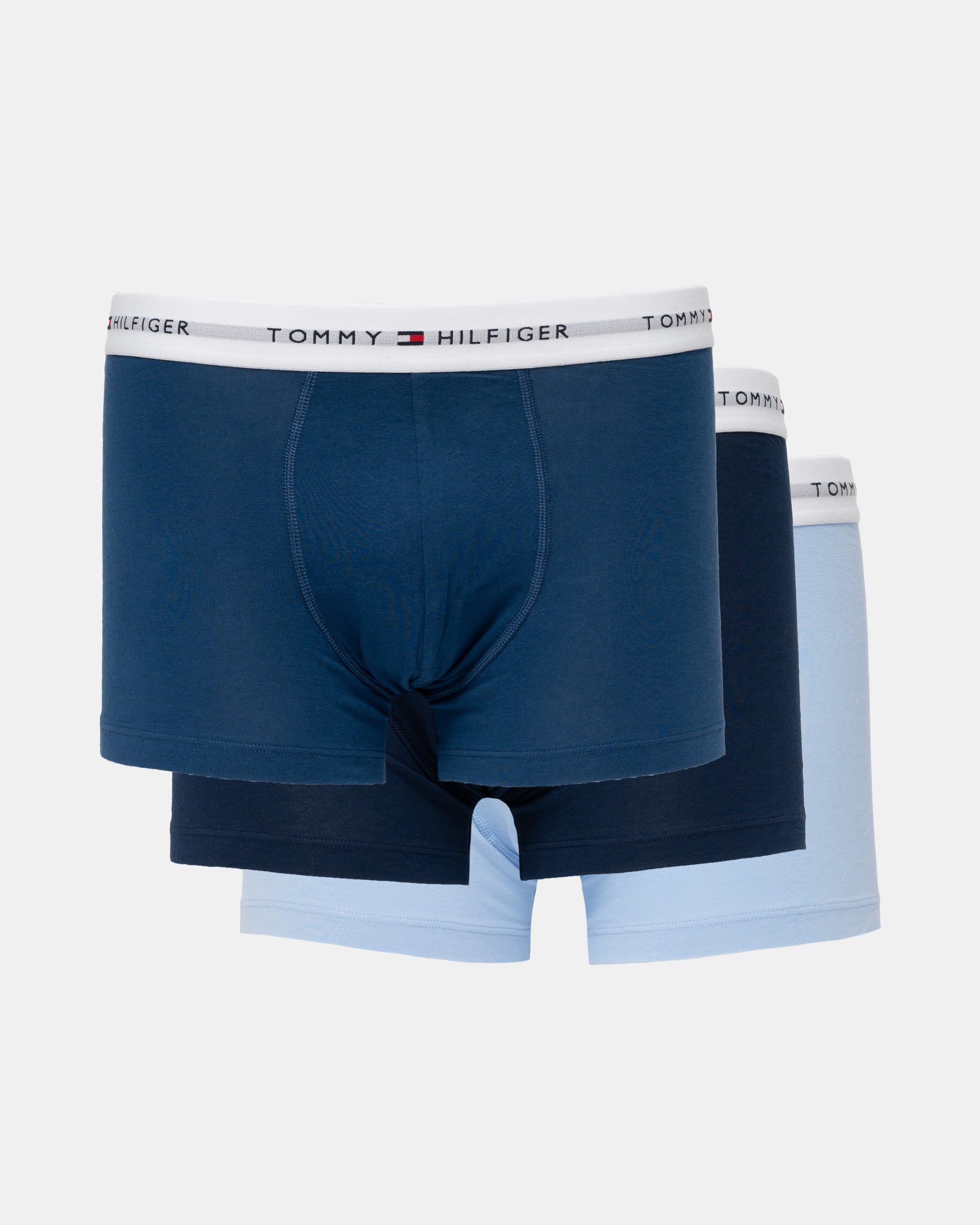 Three pairs of Tommy Hilfiger men's boxer briefs in navy, dark navy, and light blue, arranged in a stack against a light gray background.