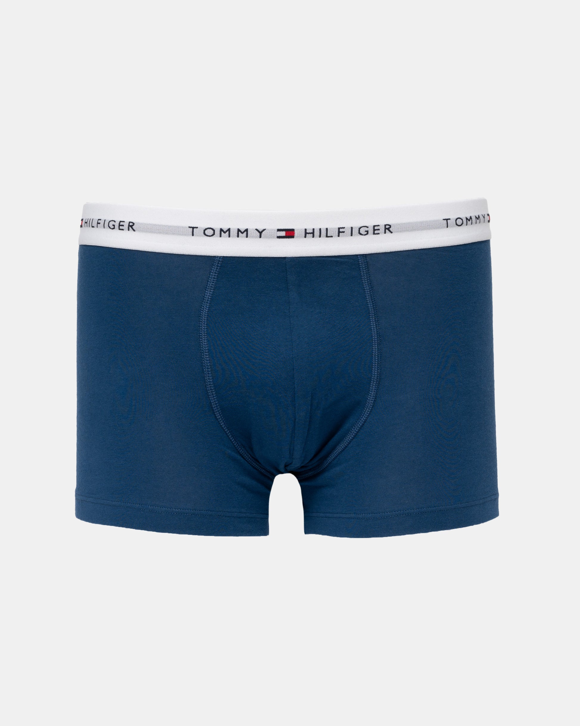 A pair of Tommy Hilfiger men's boxer briefs in navy blue, featuring a white elastic waistband with the brand's logo and name printed repeatedly.