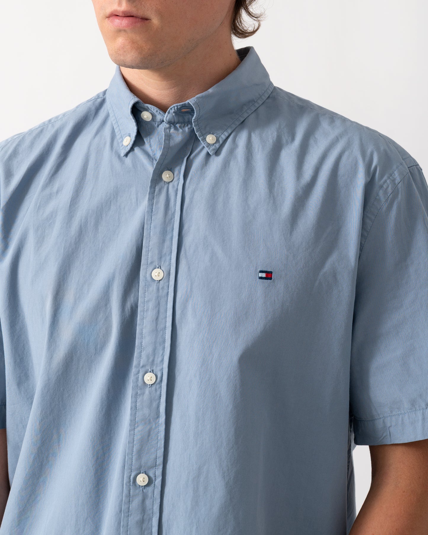 close up shot of a model wearing a Tommy Hilfiger GMD Poplin Mens Short Sleeve Shirt in Brisk Blue