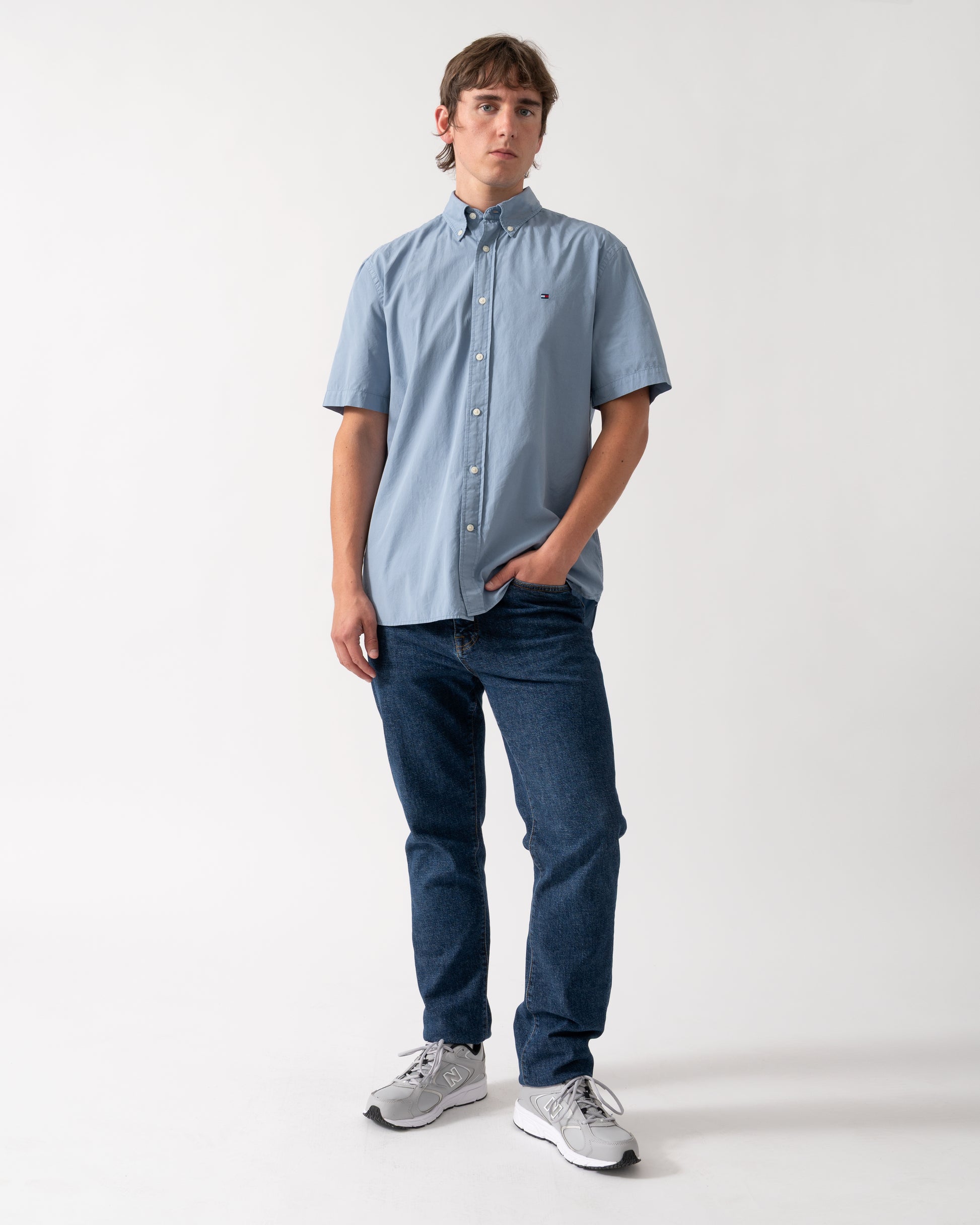 full length shot of a model wearing a Tommy Hilfiger GMD Poplin Mens Short Sleeve Shirt in Brisk Blue