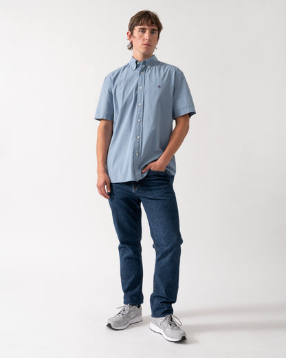 full length shot of a model wearing a Tommy Hilfiger GMD Poplin Mens Short Sleeve Shirt in Brisk Blue