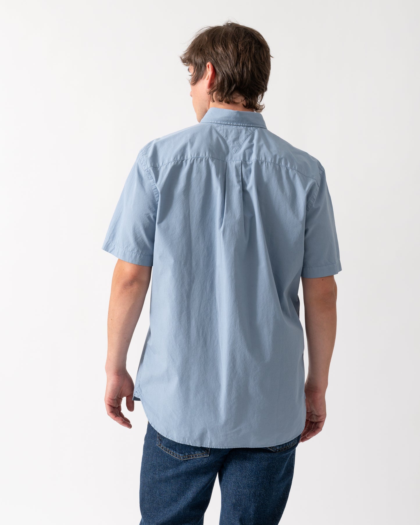 back shot of a model wearing a Tommy Hilfiger GMD Poplin Mens Short Sleeve Shirt in Brisk Blue