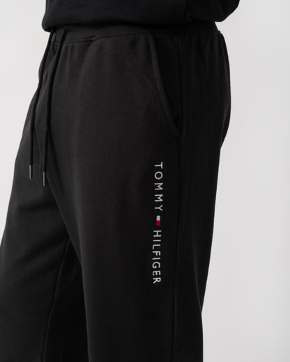 logo shot of a model wearing Tommy Hilfiger Mens Track Joggers in Black