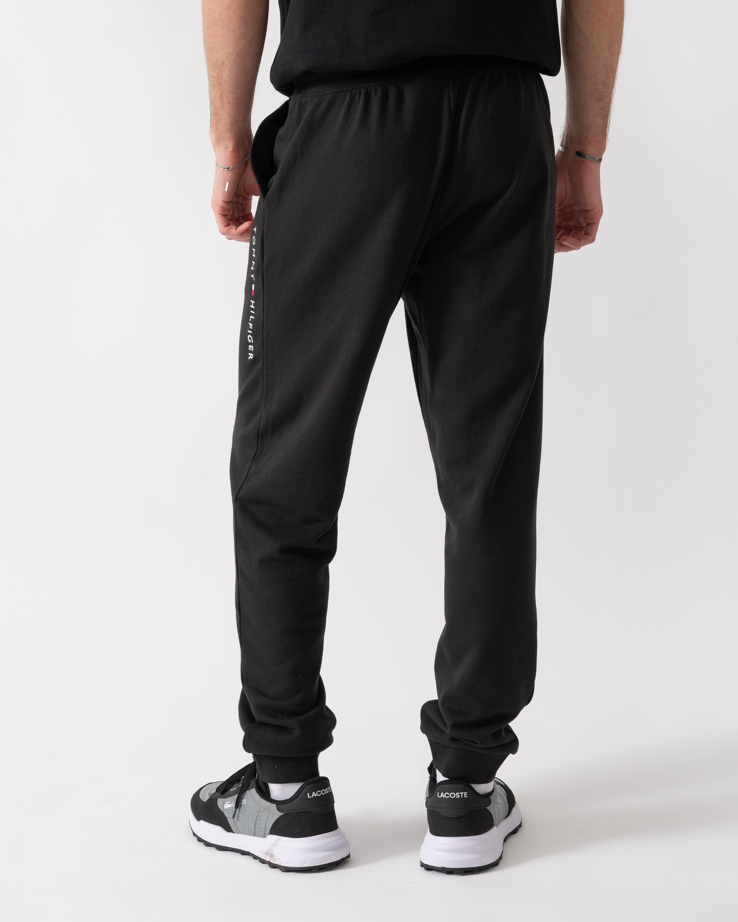 back shot of a model wearing Tommy Hilfiger Mens Track Joggers in Black