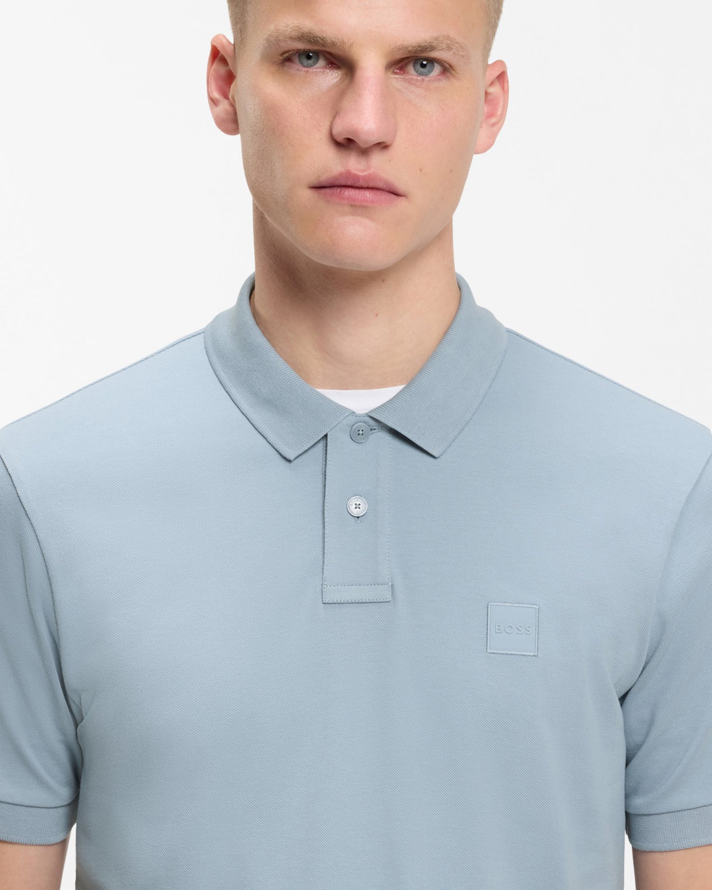 Model wearing BOSS Orange Passenger Mens Stretch-Cotton Slim-Fit Polo Shirt with Logo Patch in Light/Pastel Blue 458 - Close up