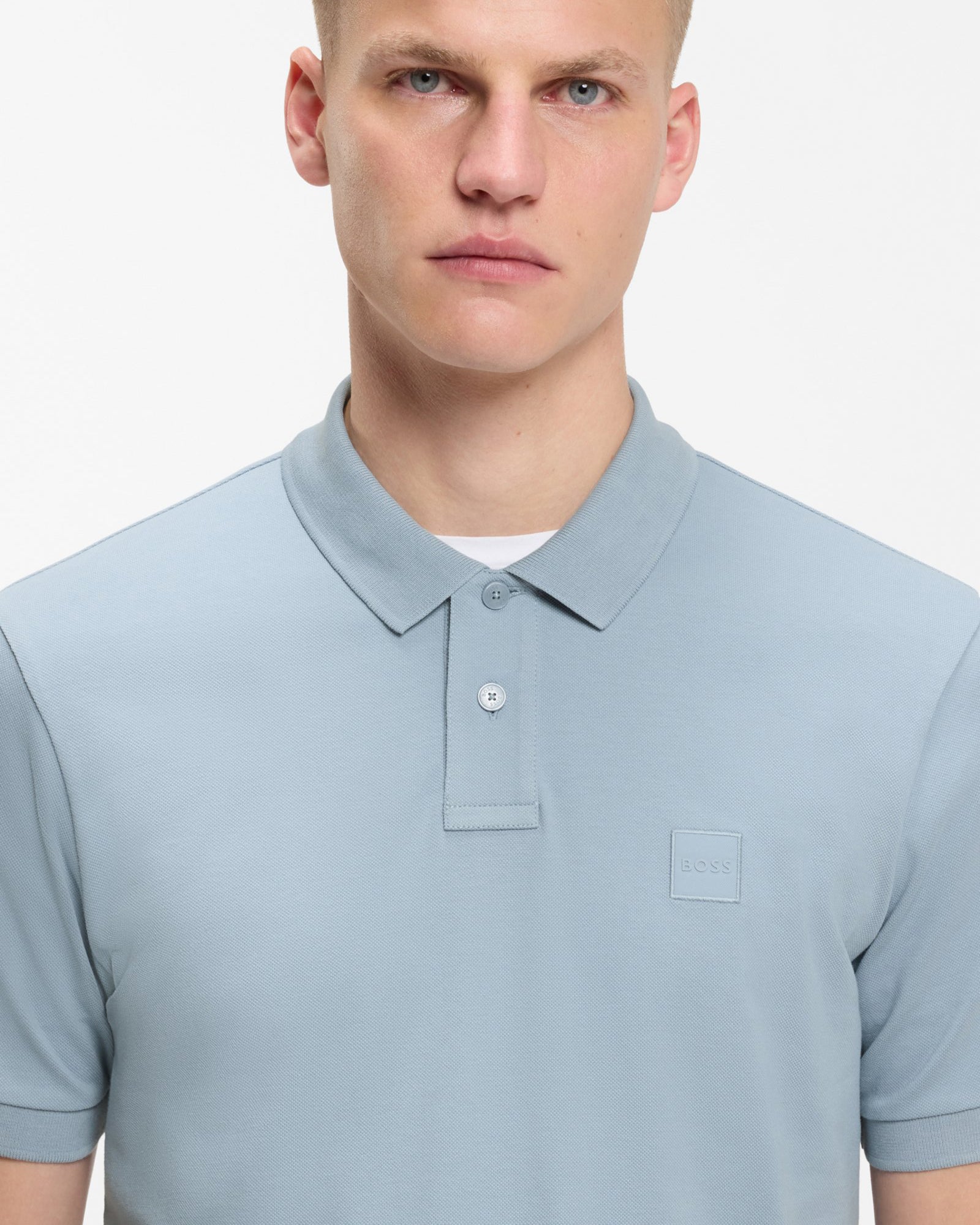 Model wearing BOSS Orange Passenger Mens Stretch-Cotton Slim-Fit Polo Shirt with Logo Patch in Light/Pastel Blue 458 - Close up